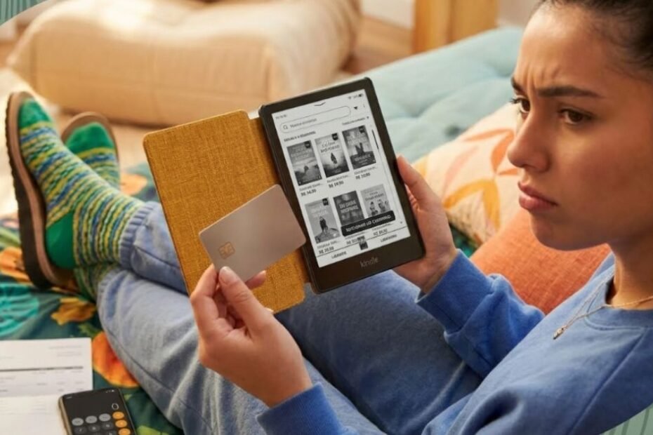Pessoa em dúvida segurando um Kindle enquanto decide se deve cancelar o Kindle Unlimited e se a assinatura ainda vale a pena